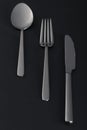 Abstract image of knife, spoon and fork on dark background Royalty Free Stock Photo