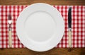 Empty plate with fork and knife on tablecloth over