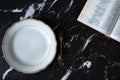 Empty plate, fork, and an open Holy Bible Book on a dark granite background