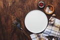 Empty plate with forks, napkin and spices on vintage wooden kitchen table, rustic setting, ready to serve, top view