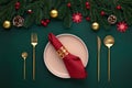 Empty plate, golden cutlery. Festive table setting, christmas decorations. Celebration xmas eve: flat arrangement. Red, gold Royalty Free Stock Photo
