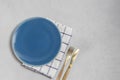 Empty plate and kitchen textile napkin with silverwear