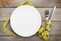 Empty plate with measure tape, knife and fork Royalty Free Stock Photo