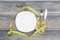 Empty plate with measure tape, knife and fork. Royalty Free Stock Photo