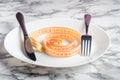 Empty plate with measuring tape, knife and fork. Royalty Free Stock Photo