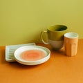 Empty plate and mug cup on orange table Royalty Free Stock Photo