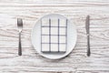 Empty plate napkin fork knife silverware white wooden table background Royalty Free Stock Photo