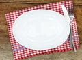 Empty plate, silverware and towel over wooden table Royalty Free Stock Photo