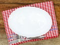 Empty plate, silverware and towel over wooden table Royalty Free Stock Photo