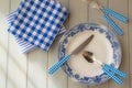 Empty plate, silverware and towel over wooden table background. View from above, blue colors Royalty Free Stock Photo