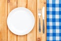 Empty plate, silverware and towel over wooden table background Royalty Free Stock Photo