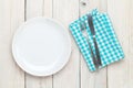 Empty plate, silverware and towel over wooden table background Royalty Free Stock Photo