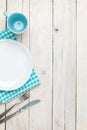 Empty plate, silverware and towel over wooden table background Royalty Free Stock Photo