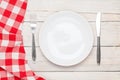 Empty plate, silverware and towel over wooden table background Royalty Free Stock Photo