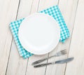 Empty plate, silverware and towel over wooden table background Royalty Free Stock Photo