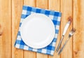 Empty plate, silverware and towel over wooden table background Royalty Free Stock Photo