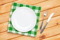 Empty plate, silverware and towel over wooden table background Royalty Free Stock Photo