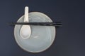 Empty plate, spoon and chopsticks on black table in asian restaurant, close up Royalty Free Stock Photo