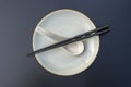 Empty plate, spoon and chopsticks on black table in asian restaurant, close up Royalty Free Stock Photo