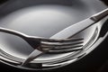 Empty plate with spoon, knife and fork on a black background Royalty Free Stock Photo