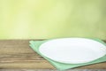 Empty plate on tablecloth or napkin on wooden table over cement background Royalty Free Stock Photo