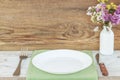 Empty plate on tablecloth or napkin on wooden table over cement background Royalty Free Stock Photo