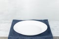 Empty plate on tablecloth on wooden table over grunge background Royalty Free Stock Photo