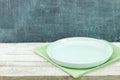 Empty plate on tablecloth on wooden table over grunge blue Royalty Free Stock Photo