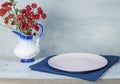 Empty plate on tablecloth on wooden table over grunge blue background Royalty Free Stock Photo