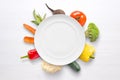 Empty plate with vegetables in background on white wooden surface Royalty Free Stock Photo