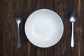 Empty plate or white dish with spoon and fork on wooden table ba Royalty Free Stock Photo