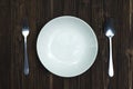 Empty plate or white dish with spoon and fork on wooden table ba Royalty Free Stock Photo