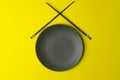 Empty plate on a yellow background. Empty plate for asian and chinese food and cuisine with chinese chopsticks Royalty Free Stock Photo