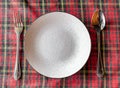 Empty plates and cutlery on table cloth on wooden table for dinner in restaurant. Flat mock up for design menu. Royalty Free Stock Photo