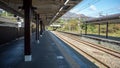 Empty platform at train station with metal sheet roof on clear blue sky background Royalty Free Stock Photo