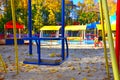 Empty playground with carousels and swings on a warm sunny autumn day