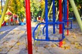 Empty playground with carousels and swings on a warm sunny autumn day