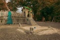 empty playground castle carousel building with wooden fence and tower for children play, autumn park land empty zone in October