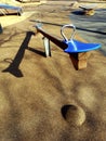 Empty playground due to the Coronavirus or Covid-19 with swing and green background. Royalty Free Stock Photo