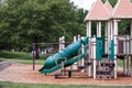 Empty playground with green slide, zip line, monkey bars and chain swings Royalty Free Stock Photo
