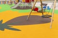 Empty playground with swings and safe rides with anti-traumatic bright rubber crumb coating Royalty Free Stock Photo