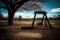 empty playground with swings and slides in the foreground, and a view of a picturesque park in the background Royalty Free Stock Photo