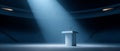 Empty podium with microphone illuminated by spotlight in large dark auditorium or stadium setting Royalty Free Stock Photo