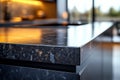 Empty polished black granite kitchen island reflecting warm light in a modern kitchen Royalty Free Stock Photo