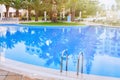 Empty pool with blue water near the luxury hotel. Palm trees, sunbeds, and Arabic style courtyard, Africa, Tunisia. Reflection of Royalty Free Stock Photo