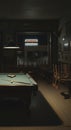 Empty pool hall with a single billiard table under a dim light creating a moody and atmospheric scene Royalty Free Stock Photo