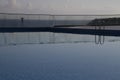 Empty pool with the reflection of the glass fence and a ladder on a cloudy day in Nicosia, Cyprus Royalty Free Stock Photo
