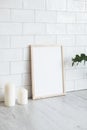 Empty poster frame in cozy interior. Frame mockup. Brick tiles wall on background. Scandinavian, nordic style Royalty Free Stock Photo