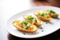 empty potato skins on a white plate with a parsley garnish Royalty Free Stock Photo
