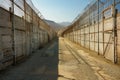 Empty prison yard with high walls and razor-wire fences